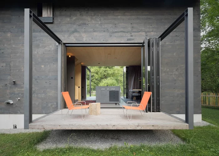 Die schwebende Terrasse wirkt wie ein Steg in die Natur. Die Glas-Faltwände verlängern diesen optisch durch das komplette Erdgeschoss bis zur gegenüberliegenden Terrasse.