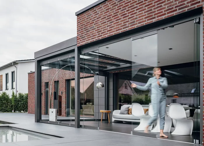 Mit den beweglichen Glaselementen lässt sich das Terrassendach einfach verschließen und schützt so vor zugigem Wind und wärmt sich schneller auf.